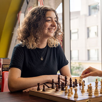 A woman playing chess. Links to Donor-Advised Funds